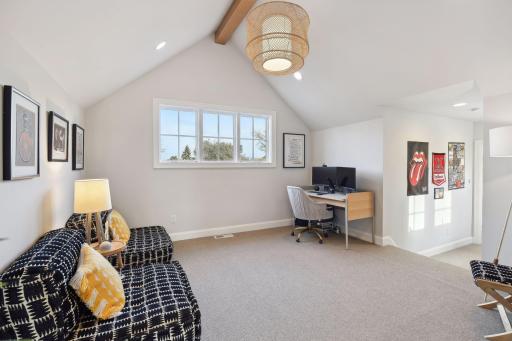 The upper-level bonus room with a vaulted ceiling sits in between the additional bedrooms upstairs. It's definitely the perfect place to lounge, play games or work!