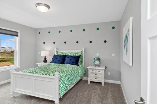 The second generously sized secondary bedroom with a spacious closet. (Photo of decorated model, actual home's finishes may vary slightly)