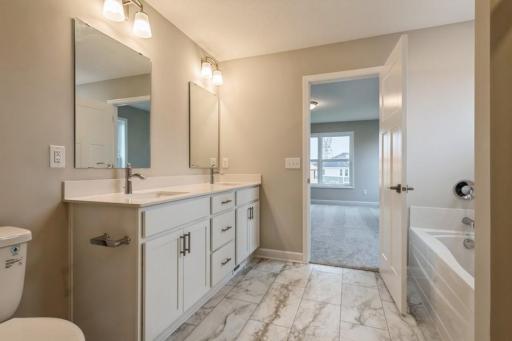Private Primary's Bathroom with a double vanity, soaking tub and a separate shower.
