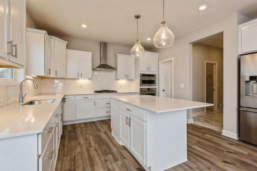 The kitchen features quartz counters, stainless appliances, including an oven with convection cooking and a gas cooktop.