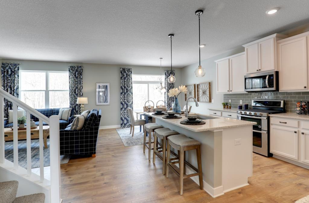 The kitchen is one of performance, and features quartz countertops, tiled backsplash, durable flooring, walk-in pantry and stainless steel appliances. Just an awesome set-up! *photo of model with same floor plan. Selections will differ.