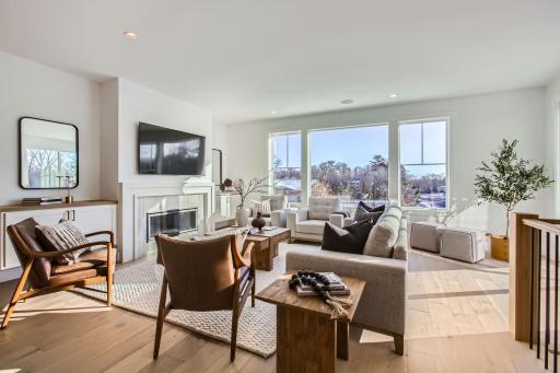 Living Room with 5" white oak flooring, gas fireplace, Marvin window and access to deck. Photos of model at 5655 Buffington.