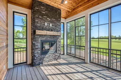 This screened/3 season porch is to die for! Composite decking, cedar walls, vinyl retractable screens and a cozy stone fireplace make this the place to be!