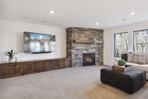 Custom floor to ceiling stone fireplace with upgraded built in cabinetry for storage and games.