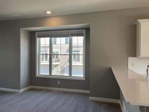 This spacious family gathering area seamlessly connects to the kitchen area, perfect for entertaining. It also features many large windows providing warm natural light.