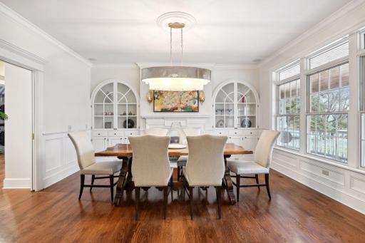 This spacious formal dining room exudes charm and features beautiful built-ins, wood burning fireplace, cove moldings and lovely views of the park-like grounds.