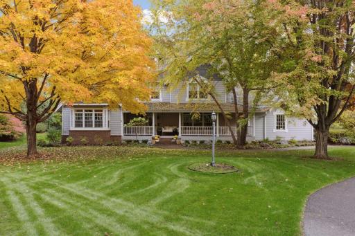 The welcoming, covered front porch offers beautiful views of the park-like yard.