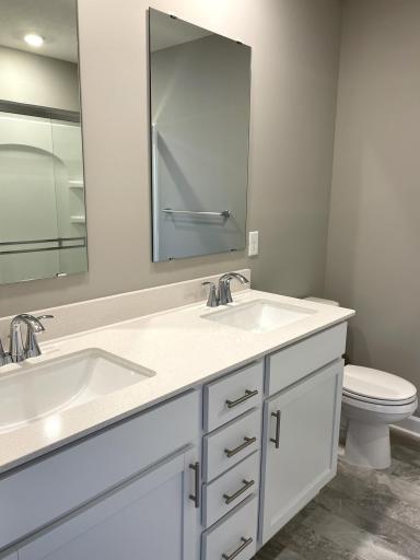 An extension of the owner's suite, this private bath contains a double-vanity and a luxurious shower.