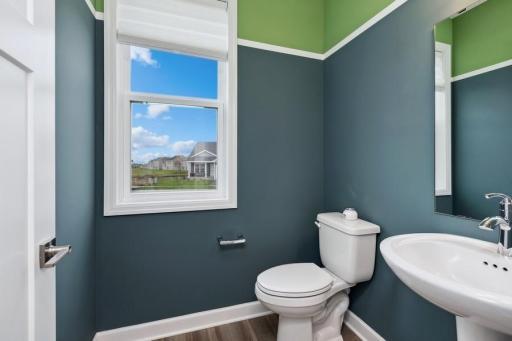 Powder bath located off mudroom on main level for added convenience. (Photo of decorated model, actual home's finishes may vary slightly)