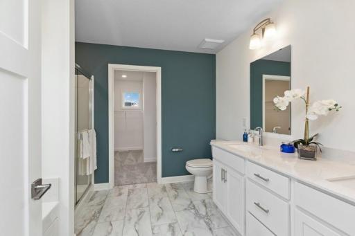 An extension of the owner's suite, this private and spacious bath contains a double-vanity, a soaking tub and a separate shower. (Photo of decorated model, actual home's finishes may vary slightly)