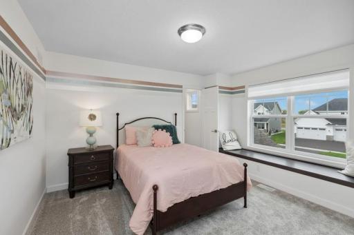 One of three generously sized upper level secondary bedrooms with spacious closets. (Photo of decorated model, actual home's finishes may vary slightly)