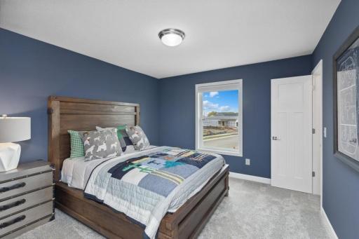 The third generously sized upper level secondary bedroom with a spacious closet. (Photo of decorated model, actual home's finishes may vary slightly)