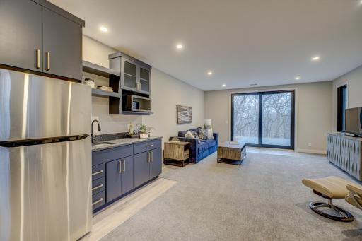 Enjoy the cozy in-floor heat, convenient wet bar, and walk out access to the paver patio with a bonfire pit