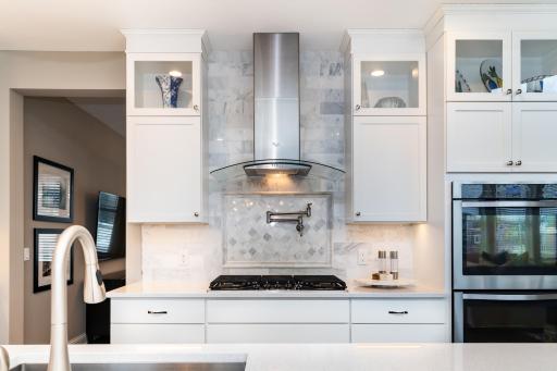 Enameled White Cabinets and Custom Lighting Throughout.