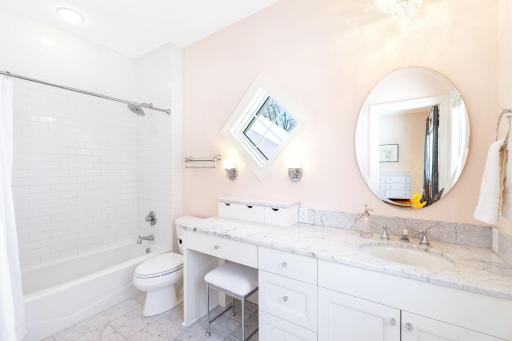 The second of four upper level bedrooms is serviced by a private, full bathroom.