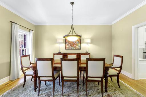 The spacious formal dining room located off the kitchen and foyer and has pocket doors with glass panes that can be closed for more privacy.