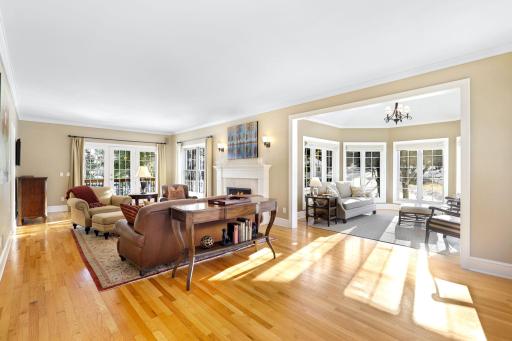 The main level living room is bright and open with natural light coming in through 3 sides of the home including the adjoining 5-sided sunroom.