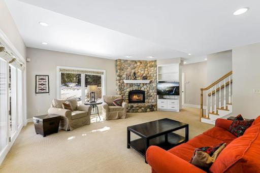 The cozy lower level family room walks out to the backyard paver patio overlooking the pond.