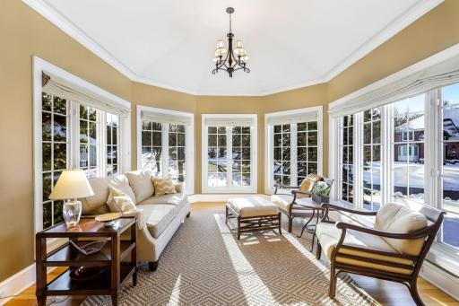 The main level living room is bright and open with natural light coming in through 3 sides of the home including the adjoining 5-sided sunroom.