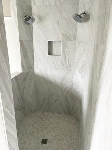 Primary suite bathroom serenity shower in timeless white tile progress photo 11.16.23.