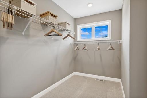 The primary suite features an incredible walk-in closet. (Photo is of a decorated model, actual homes features may vary)