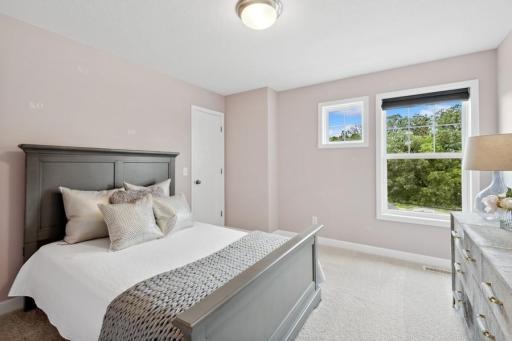 The third generously sized upper level secondary bedroom with a walk-in closet. (Photo is of a decorated model, actual homes features may vary)