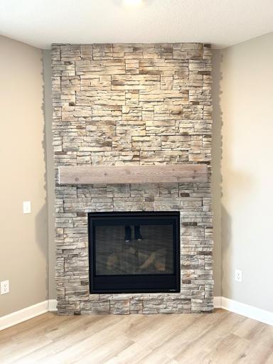 Corner gas fireplace with ceiling height Andes Summit stone and a barnwood whitewash mantle.