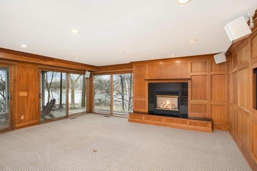 Family room has wall of windows and cosy fireplace