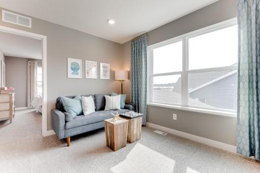 The primary suite is off the back of the home. This space (the home's loft) resides just atop the stairs and offers that second living space families of all sizes have come to appreciate! (Photos of the same floorplan, colors are similar)