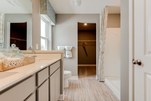 Connected to the primary suite is this bathroom, which includes a double-vanity, stand-in shower and serves as the passage way to the bedrooms oversized walk-in closet! Please see Sales for color selections.