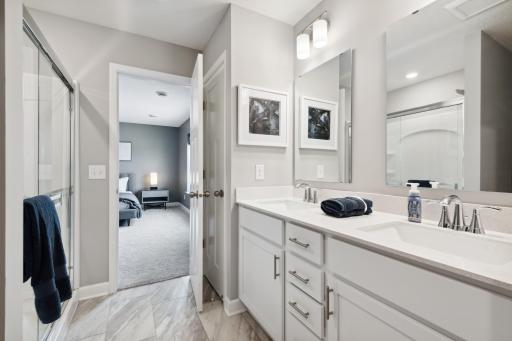 An extension of the owner's suite, this private and spacious bath includes a double-vanity and large shower. (Photo of decorated model, actual home's finishes may vary slightly)