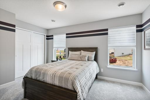 One of three generously sized upper level secondary bedrooms with spacious closets. (Photo of decorated model, actual home's finishes may vary slightly)