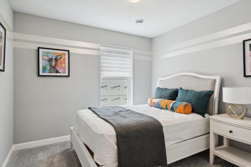 The third generously sized upper level secondary bedroom with a spacious closet. (Photo of decorated model, actual home's finishes may vary slightly)