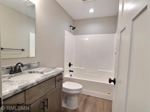 The main full bath of the home is centrally located and offers granite countertops and vinyl plank flooring.