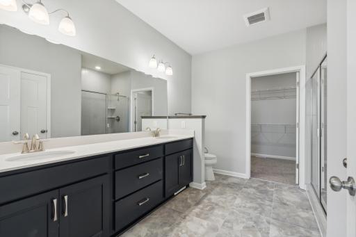 This owner's bath offers a double vanity and step-in shower plus a linen closet.