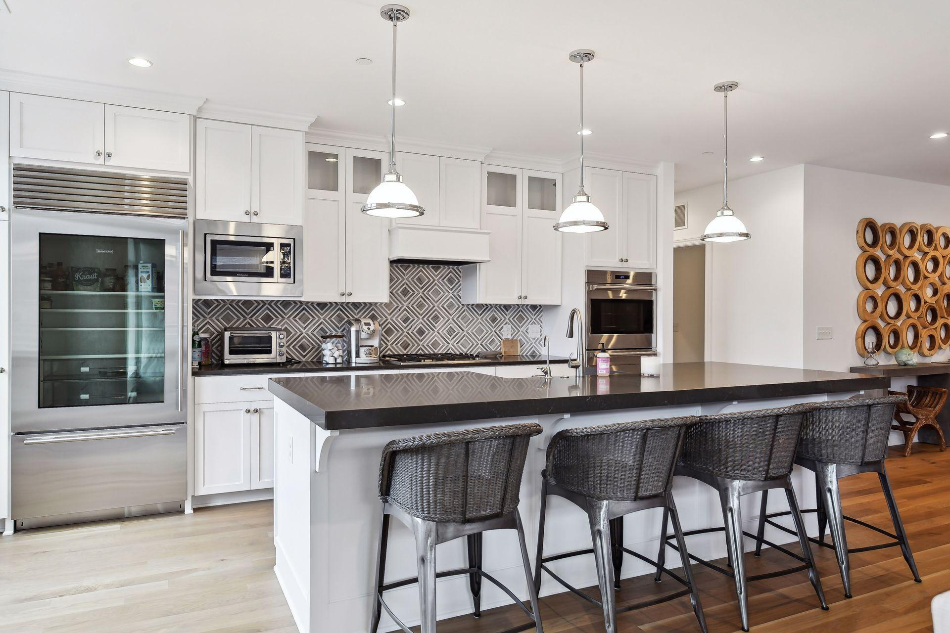 High-end SS appliances including gas cooktop, double wall ovens, and glass paneled refrigerator