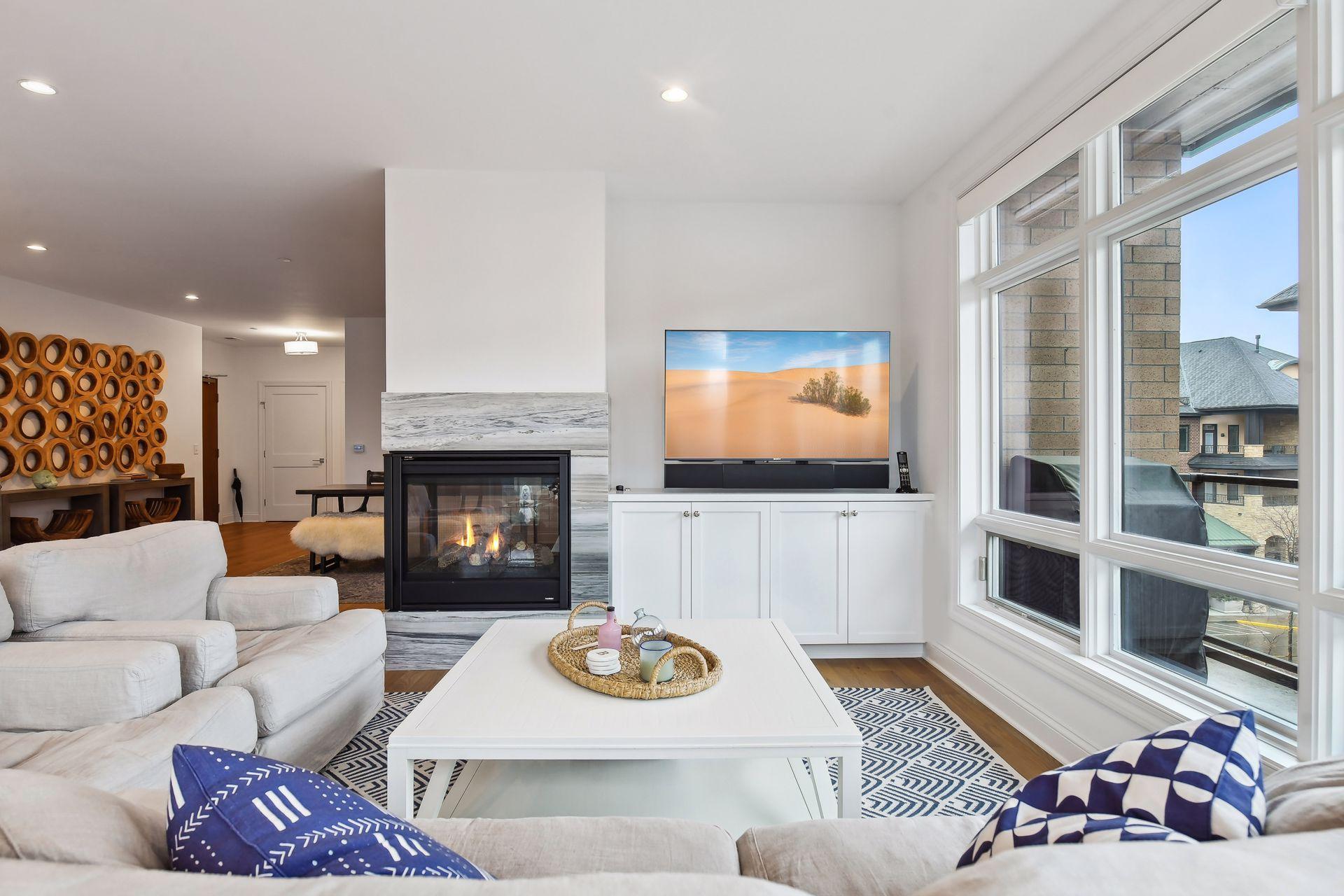 Built-in cabinets and three-sided fireplace are highlights of this space