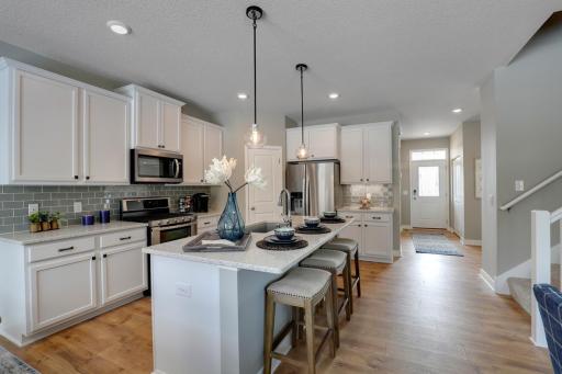 A wonderful cozy kitchen that flows into the family room with the dinette off to the side. MODEL HOME PHOTOS, COLORS AND SELECTIONS WILL VARY.