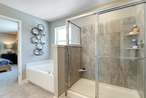 An additional angle of the deep soaking tub and separate shower in the primary bathroom. MODEL HOME PHOTOS, COLORS AND SELECTIONS WILL VARY.