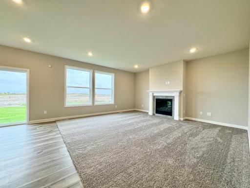 The large great room includes centered fireplace with tile surround. Photos of similar home, actual colors and finishes may vary.