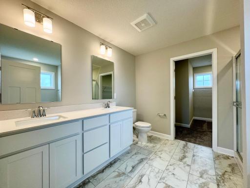 An extension of the owner's suite, this private and spacious bath contains a double-vanity, a soaking tub, separate shower and access to the walk-in closet. Photos of similar home, actual colors and finishes may vary.