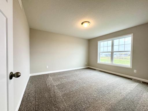 One of four upper level bedrooms, all with walk in closets! Photos of similar home, actual colors and finishes may vary.