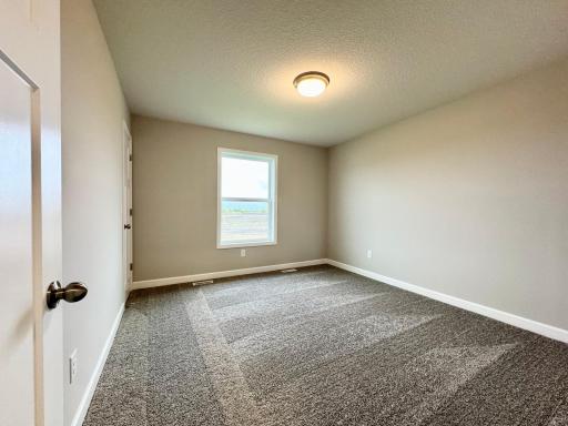 One of four upper level bedrooms, all with walk in closets! Photos of similar home, actual colors and finishes may vary.