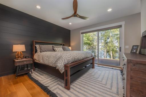 Primary bedroom with sliding glass doors that lead you out to the lake side deck..jpg