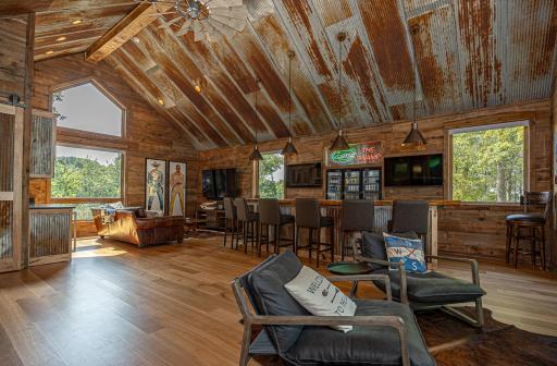 Bar adorned with barn wood accented by tin roofs with 3 TVs set up to make sure you can view all the action.jpg