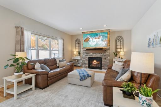 Cozy living room with floor to ceiling stone surrounding the gas fireplace.