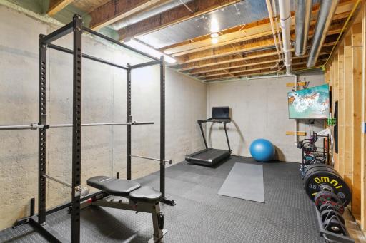 Unfinished area of basement, currently used for exercise and storage
