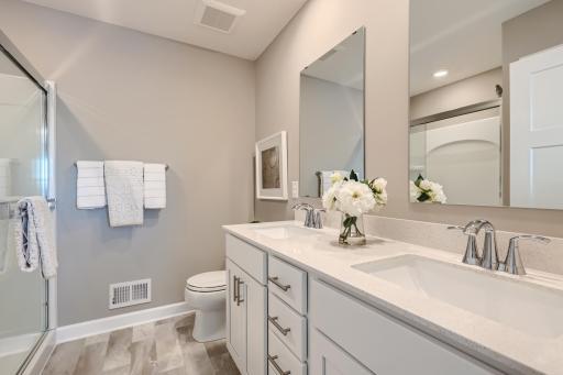 An extension of the owner's suite, this private and spacious bath contains a double-vanity and a luxurious shower. (Photo of decorated model, actual home finishes may vary slightly)
