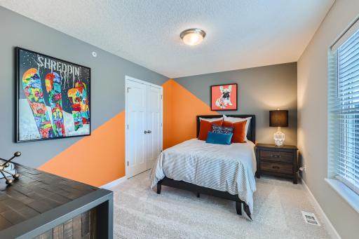 Each of the home's secondary bedrooms on the upper level come perfectly sized and feature a spacious closet. (Photo of decorated model, actual home finishes may vary slightly)