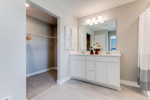 An extension of the primary suite, this private & spacious bathroom contains a double-vanity, a stand-in shower & access to a large walk-in closet!! Photo of model home, color & options may vary.